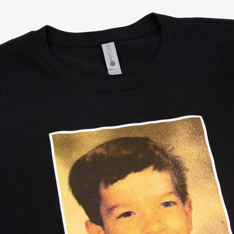 Closeup of black shirt with photo on front of John Mulaney as a kid